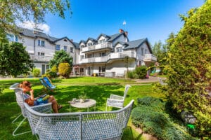 Dom Wczasowy Rudnik w Chłapowie – ogród z leżakami i widokiem na budynek