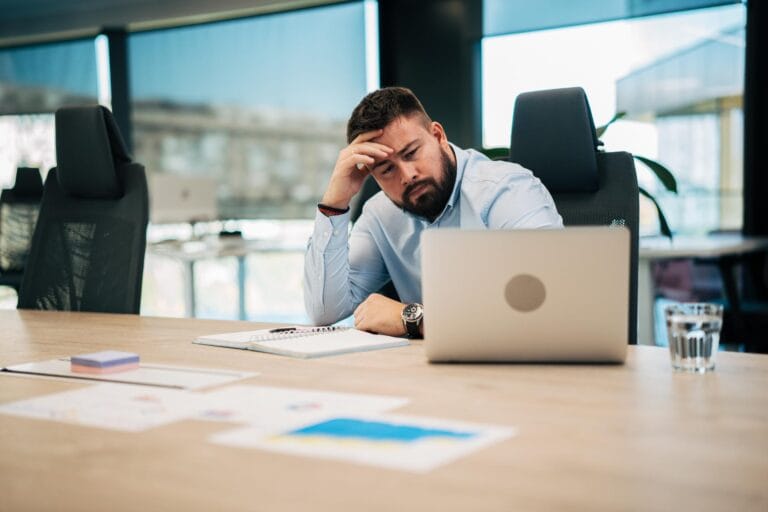 Czy Polacy nienawidzą swojej pracy – zmęczony pracownik przy biurku pokazujący stres i wypalenie zawodowe w pracy
